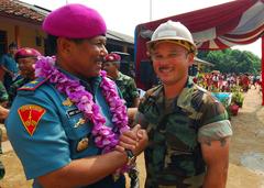 Indonesian Marine Corps Brig. Gen. Arif Suherman shakes hands with U.S. Navy Builder 3rd Class Jermaine Takai at a ribbon cutting ceremony in Jakarta