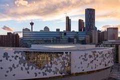 Downtown Calgary skyline with modern skyscrapers and lush green trees