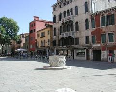 A piazza with parked cars and surrounding buildings