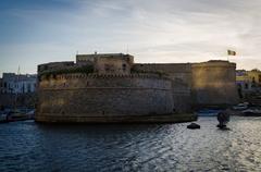 sunset view of a small castle by the river in Italy