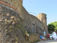 Riomaggiore castle with stone walls and tower under a clear blue sky