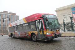 Mount Vernon Place covered in snow in Baltimore, Maryland during a bomb cyclone with a Baltimore CityLink Green bus arriving at the bus stop