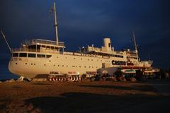 The Lydia ship docked on a sandy beach with a blue sky background