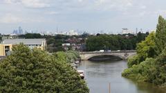 Brentford-side arch of Kew Bridge at high tide with London skyline in the background