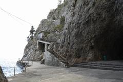 Concrete platform in front of the Smeraldo Cave entrance with a closed outer staircase