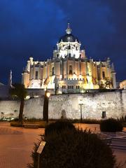 Rear facade of Almudena Cathedral in Madrid, Spain viewed from Mohamed I Park with remnants of the Islamic wall