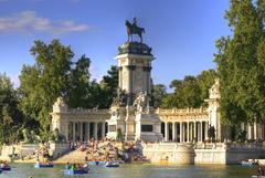 Monument at Retiro Park with lake and boats