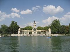 Scenic view of Buen Retiro Park with trees, people walking, and a serene atmosphere