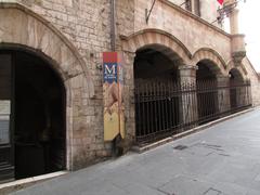 Fountain of Portica Street behind iron grating along Via Portica