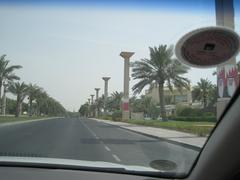 man riding a camel on a street in Bahrain