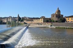 Arno River in Florence with buildings along the riverbank on a sunny day