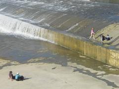 people walking on the Arno artificial waterfall