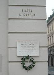 Memorial to Libero Tubino at Piazza San Carlo in Turin with historical buildings in the background