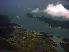 Aerial view of Kau Sai Chau, an island in Hong Kong, featuring lush green hills, rocky coastline, and blue surrounding waters