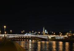 Bolshoy Moskvoretsky Bridge illuminated at night with Kremlin's Beklemishevskaya Tower and Bell Tower Ivan the Great in the background