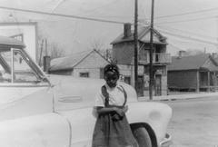 Clara Meekins next to a canary yellow 1953 Pontiac convertible on South Street, Raleigh, NC, in 1957