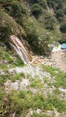 Kempty Fall waterfall in Mussoorie surrounded by lush green hills