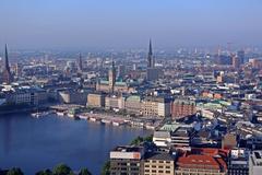 A panoramic view of Hamburg, including the Hamburger Rathaus, St. Nikolai, St. Katharinen, St. Petri, and Elbphilharmonie