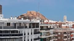 panoramic view of Santa Barbara Castle at sunset from a high-rise rooftop in Alicante