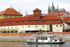 Tour boat passing in front of the Franz Kafka Museum in Prague