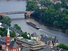 cargo ship sailing upstream near the Alte Bruecke over the Main river in Frankfurt