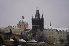 Scenic view of Vltava river with snow-covered trees and historic buildings