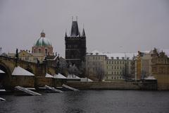 Man kayaking on the Vltava River with snowy shores