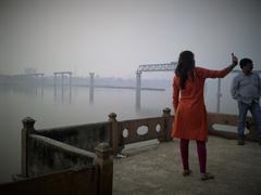 Woman in orange-red kurta taking a selfie at Ram Nagar Fort balcony