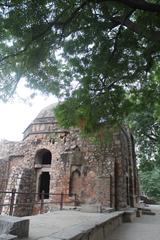 A small historical building surrounded by lush vegetation