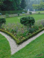 view of Benrather Park with boxwood hedge and seasonal statues in the background