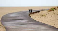 sandbank bench with umbrella on a rainy beach in Leucate