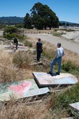 Hikers on concrete slabs next to a trail near Albany Bulb beach