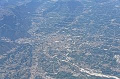 Aerial view of an airplane wing and landscape below