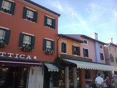 Picturesque coastal town of Caorle with colorful buildings, a bell tower, and a boat docked along the waterfront