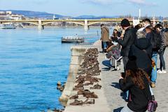 Tourists photographing the Shoes on the Danube Bank monument in Budapest, Hungary