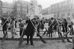 Hostesses and stewardesses in Amsterdam cleaning with municipal official Goekoop, 15 April 1976