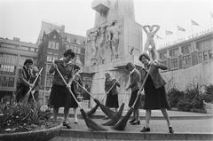 Hostesses of VVV clean Dam Square in Amsterdam during Easter campaign, April 15, 1976