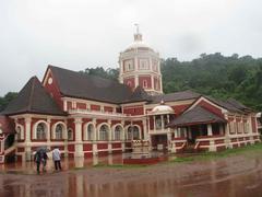 Mangeshi Temple in Goa at dusk with illuminated temple structures and a clear sky