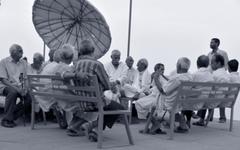 Elderly people in group chat at Assi Ghat in the evening