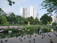 Banjasiri Park landscape view with lush greenery and modern buildings in the background.