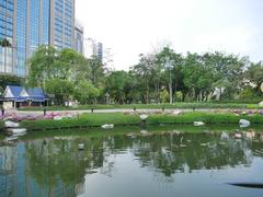 Scenic lake view in Banjasiri Park with lush green trees and a traditional Thai pavilion in the background