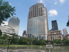 Banjarsiri Park in Bangkok featuring a bronze statue of Queen Sirikit in front of a lush garden