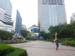 Banjasiri Park in Bangkok with lush green trees and a serene water pond