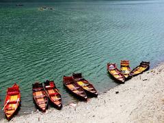 A serene lake view with a boat and mountains in Bhimtal, Uttarakhand