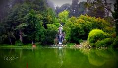 serene lake with reflections of trees and a small waterfall