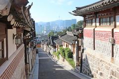 Bukchon Hanok Village in Seoul with traditional Hanok houses and a view of modern buildings in the background