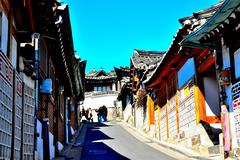 a scenic view of Bukchon Hanok Village with traditional Korean houses and modern buildings in the background