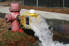 fire hydrant flushing water via a diffuser in front of Durham School of the Arts, West Morgan Street, Durham, North Carolina