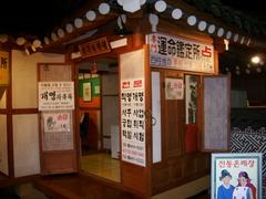 Naming service hut at Lotte World in South Korea with a sign on the left discussing the legality of changing names