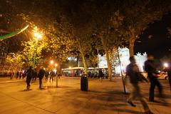 Pedestrians walking near Puerta de Alcalá, Madrid in the evening